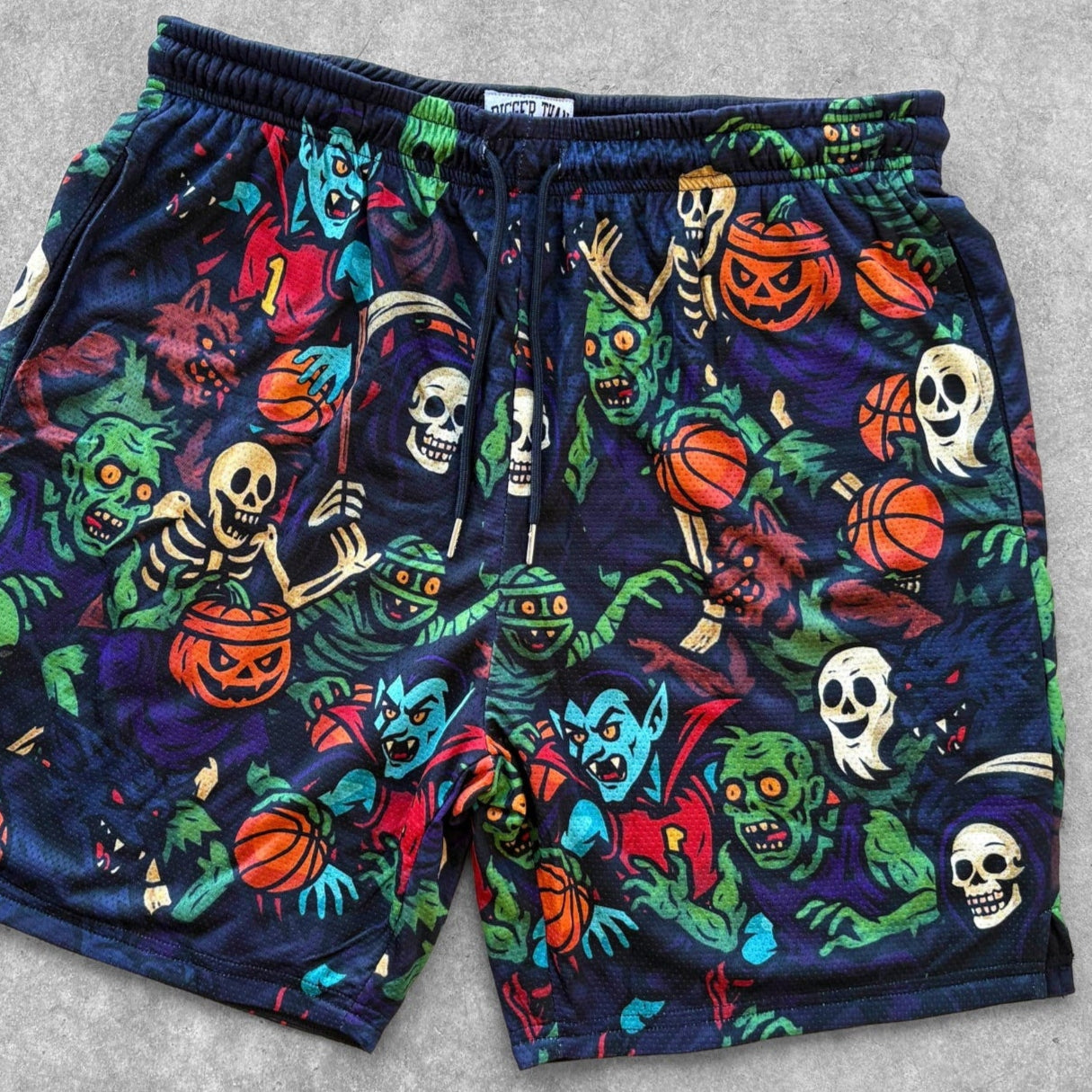 Colorful Halloween-themed shorts with various characters on a gray background